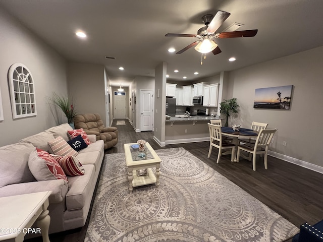 living room featuring recessed lighting, dark wood finished floors, and baseboards