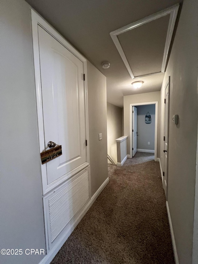 hallway featuring carpet, visible vents, baseboards, and an upstairs landing