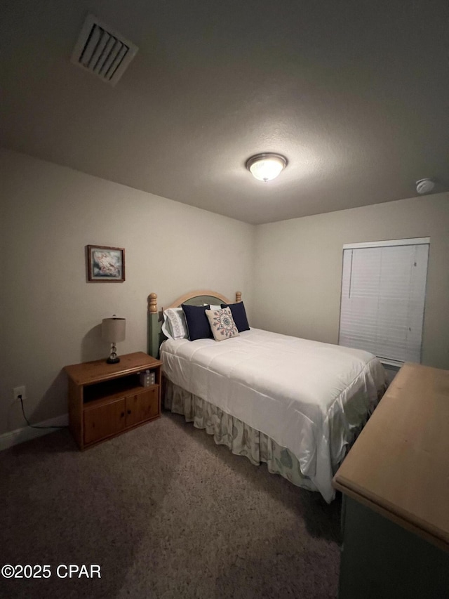 bedroom with visible vents and dark carpet