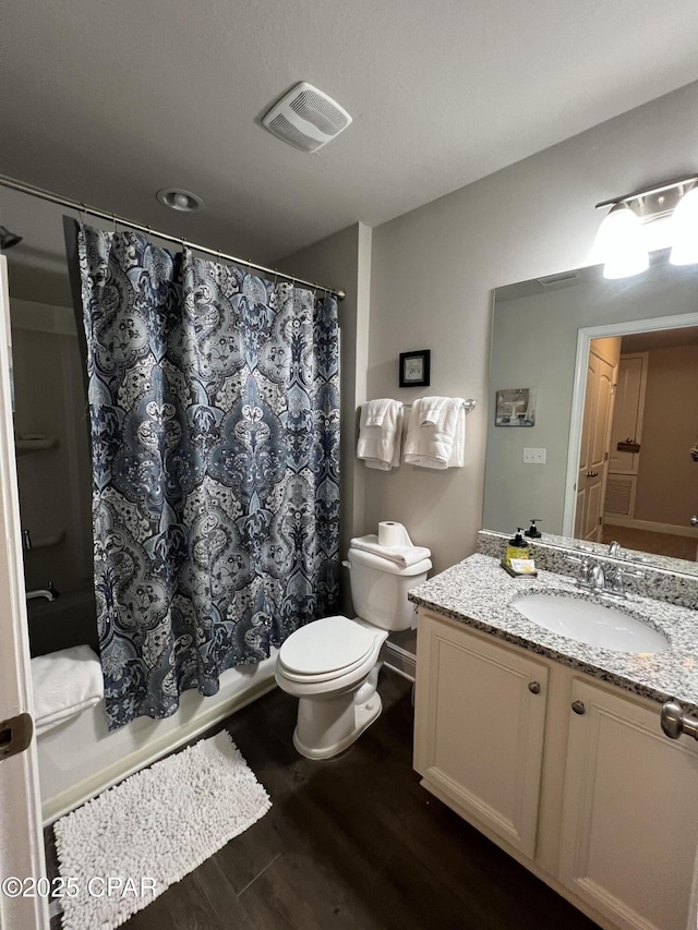 bathroom with shower / tub combo with curtain, visible vents, toilet, vanity, and wood finished floors