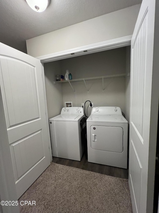 washroom with laundry area, washer and clothes dryer, and a textured ceiling