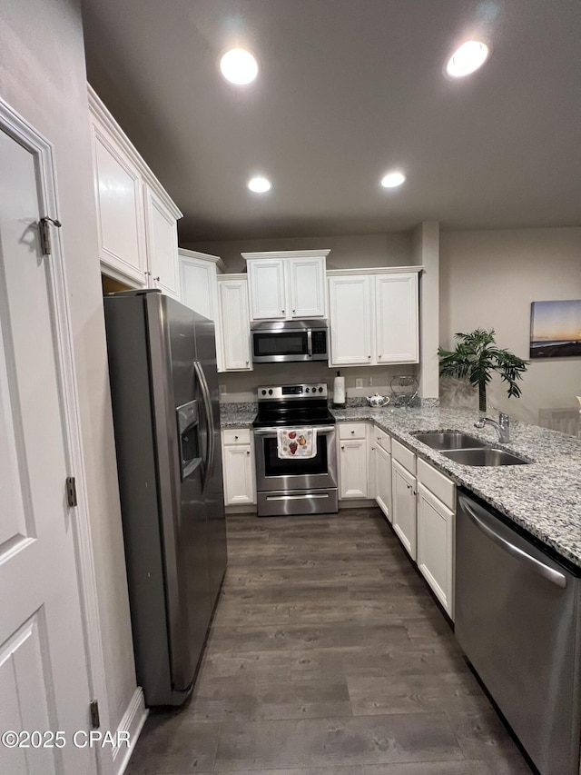 kitchen featuring appliances with stainless steel finishes, a sink, and white cabinets