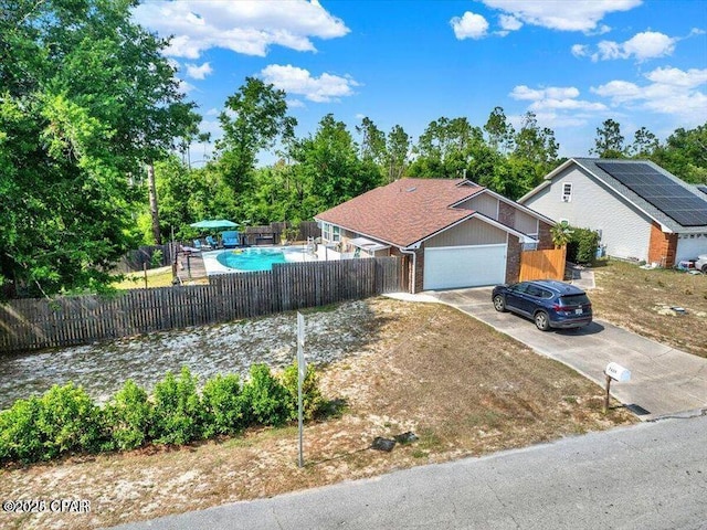 ranch-style home with driveway, a garage, a fenced in pool, fence, and brick siding