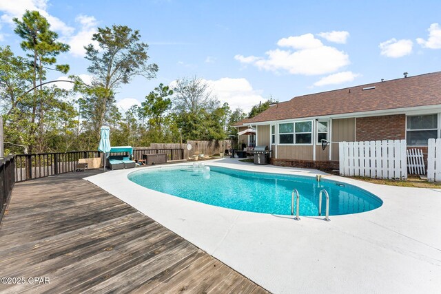 view of swimming pool featuring a fenced in pool, fence, and a deck