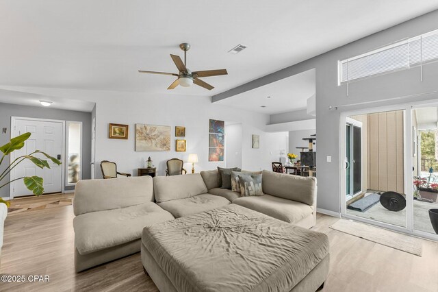 living room featuring light wood-style flooring, visible vents, and a ceiling fan