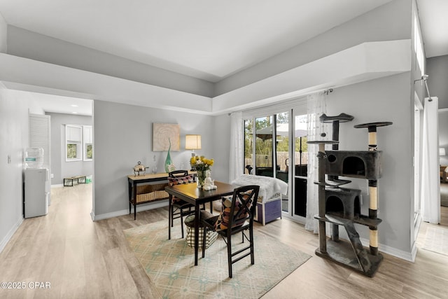 dining area with light wood finished floors and baseboards