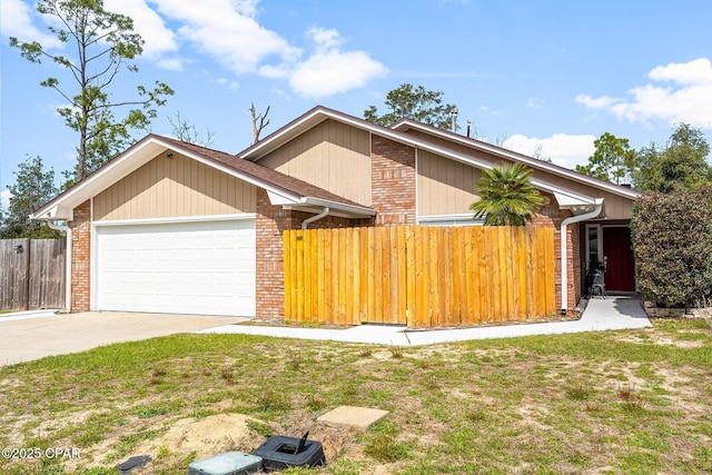 view of front of property with brick siding, concrete driveway, an attached garage, fence, and a front yard