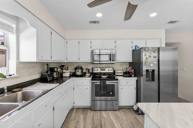 kitchen featuring appliances with stainless steel finishes, visible vents, and light wood finished floors