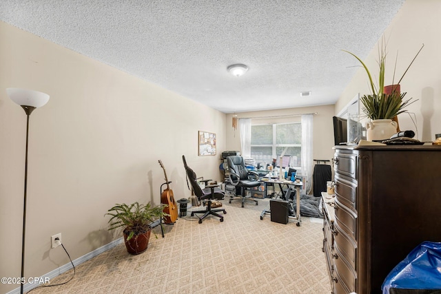 office area with carpet floors, baseboards, and a textured ceiling