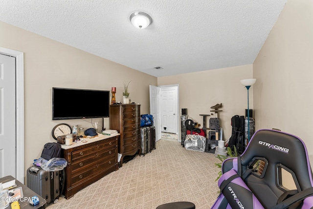 living area featuring carpet, visible vents, and a textured ceiling