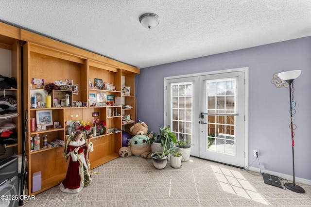 interior space featuring french doors, a textured ceiling, and baseboards