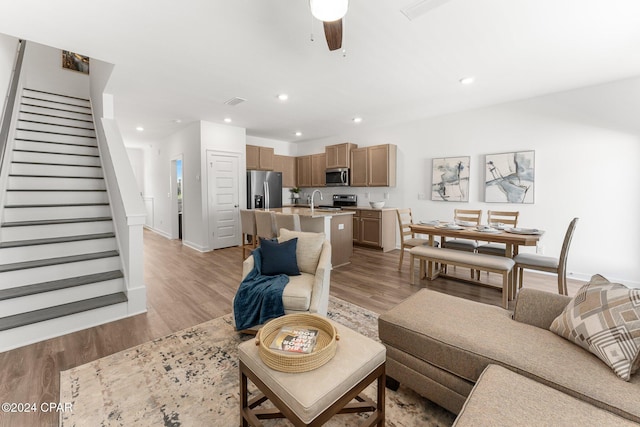 living area featuring stairs, recessed lighting, and light wood-style floors