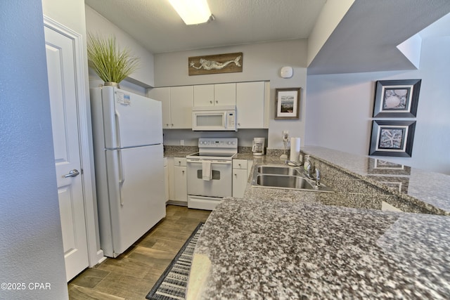 kitchen with dark wood-style floors, white cabinets, a sink, a textured ceiling, and white appliances