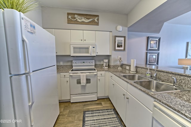 kitchen with white appliances, wood tiled floor, white cabinetry, and a sink