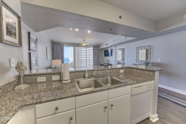 kitchen with baseboards, dark wood finished floors, dishwasher, open floor plan, and a sink