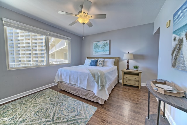 bedroom featuring ceiling fan, baseboards, and wood finished floors