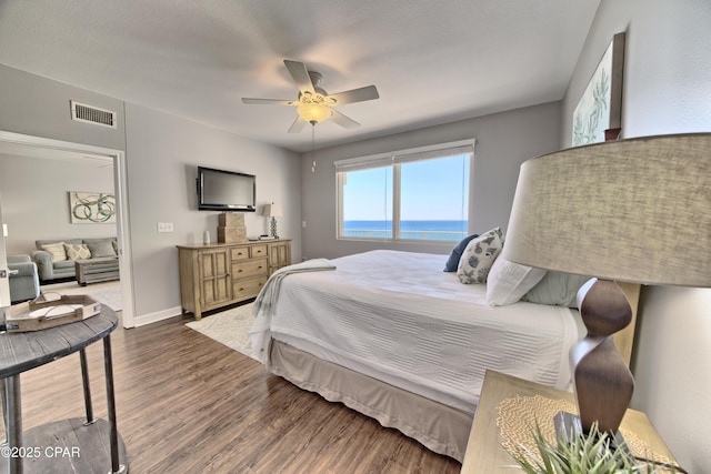 bedroom featuring ceiling fan, wood finished floors, visible vents, and baseboards