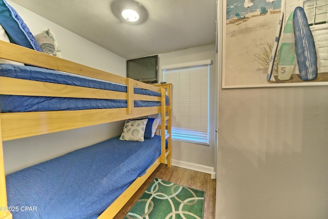 bedroom with wood finished floors and baseboards