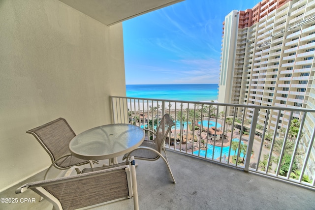 balcony with a water view and a view of the beach