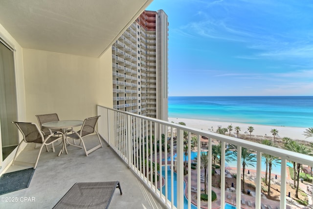 balcony featuring a view of the beach and a water view