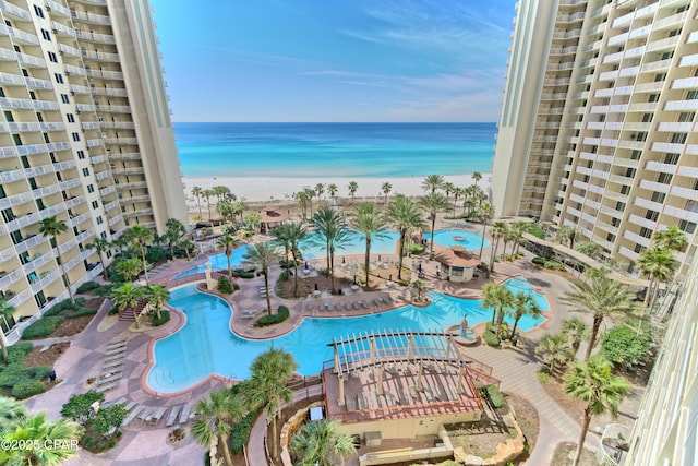 view of pool featuring a water view and a beach view