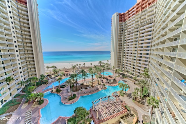 view of swimming pool with a water view and a view of the beach