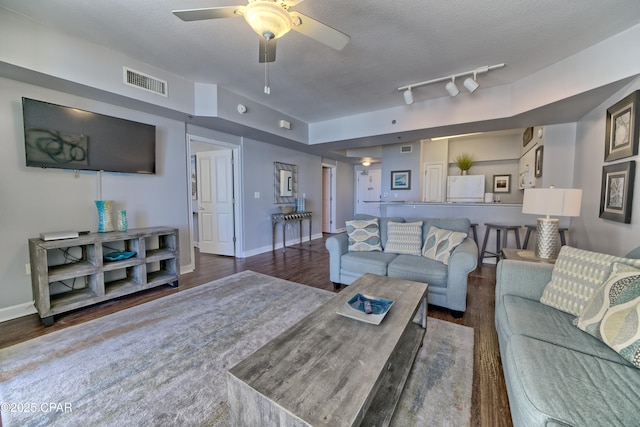 living room with baseboards, visible vents, a ceiling fan, wood finished floors, and a textured ceiling