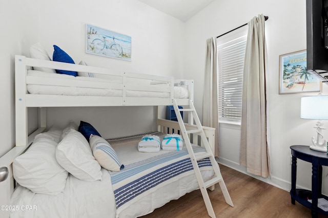 bedroom with baseboards and wood finished floors