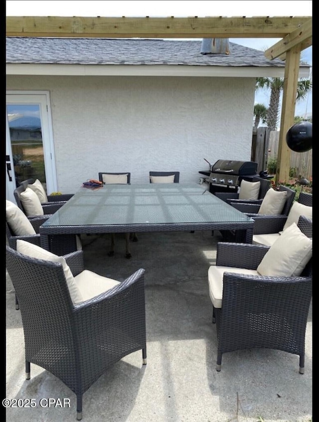 view of patio with a grill, fence, and outdoor lounge area