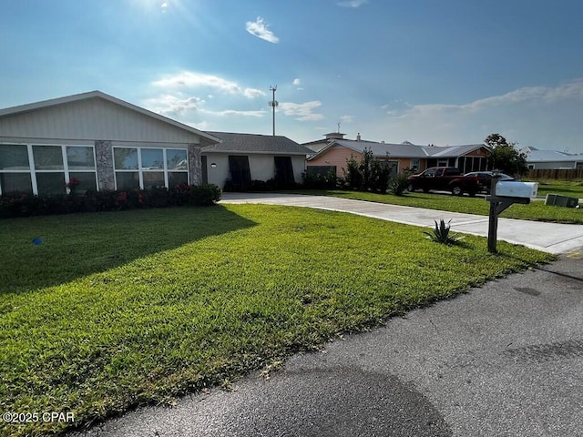 ranch-style house with concrete driveway and a front yard