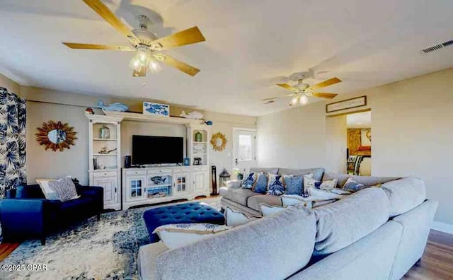 living area with visible vents, ceiling fan, and wood finished floors