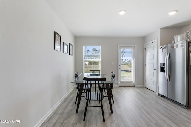 dining area with light wood-style flooring and baseboards