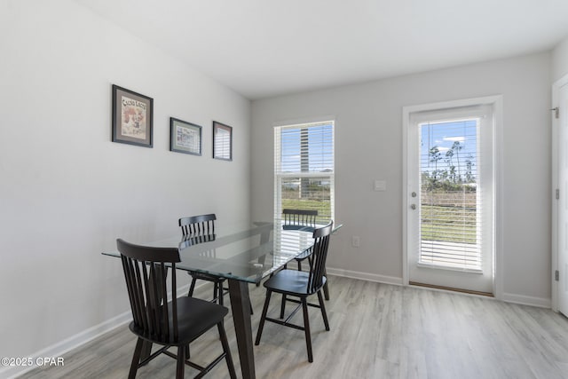 dining space with plenty of natural light, baseboards, and light wood-style flooring