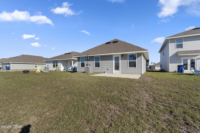 back of house featuring a patio, a yard, and roof with shingles