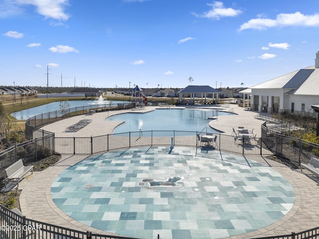 pool featuring a patio, a water view, and fence