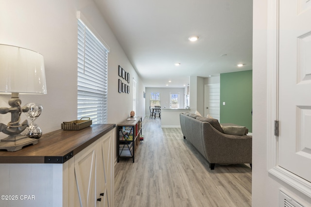 corridor with recessed lighting, light wood-style flooring, and baseboards