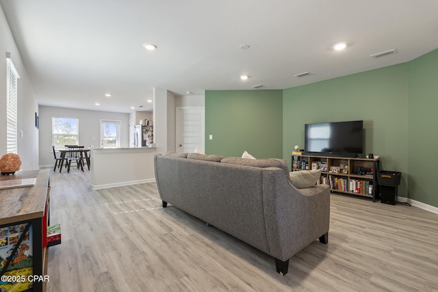 living area with light wood finished floors, baseboards, visible vents, and recessed lighting