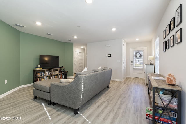 living room with recessed lighting, baseboards, and light wood finished floors