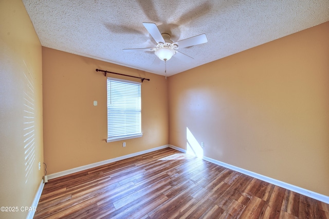 spare room with a ceiling fan, a textured ceiling, baseboards, and wood finished floors