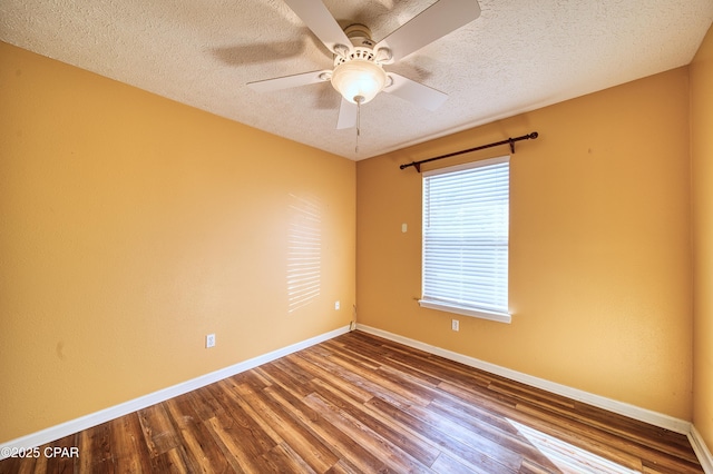 spare room with ceiling fan, a textured ceiling, baseboards, and wood finished floors