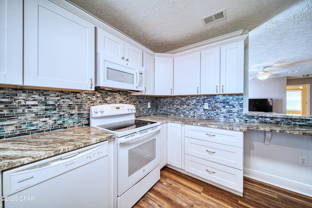 kitchen featuring white appliances, visible vents, white cabinets, light stone counters, and wood finished floors