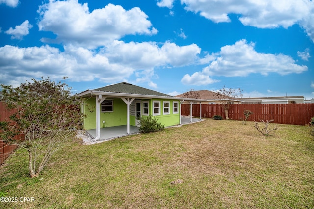 rear view of property with a patio area, a fenced backyard, a lawn, and stucco siding