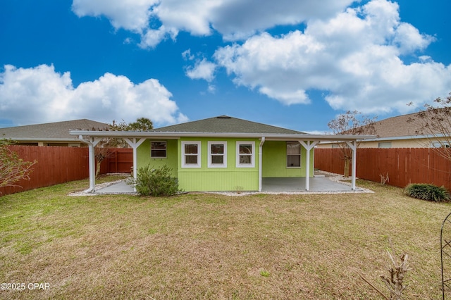 rear view of house with a lawn, a patio area, and a fenced backyard