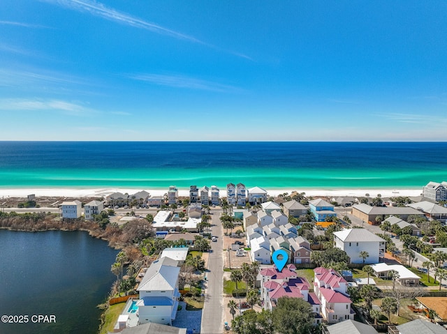 birds eye view of property with a water view, a view of the beach, and a residential view