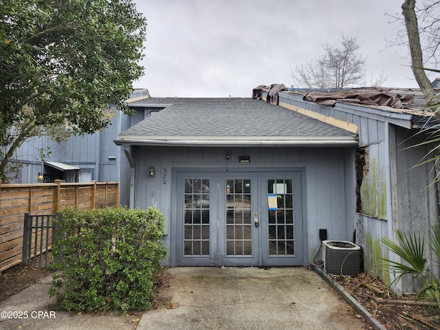 back of house featuring cooling unit, french doors, a fenced backyard, and roof with shingles