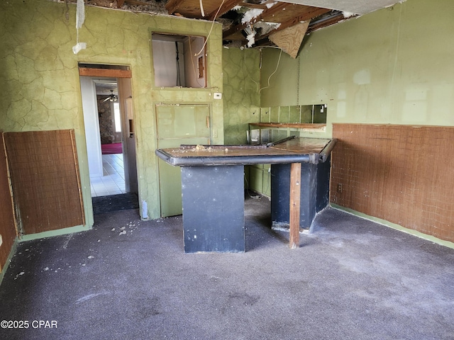 kitchen featuring dark colored carpet, a peninsula, and a kitchen breakfast bar