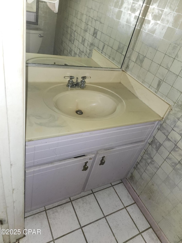 bathroom with tile patterned flooring, tile walls, and vanity