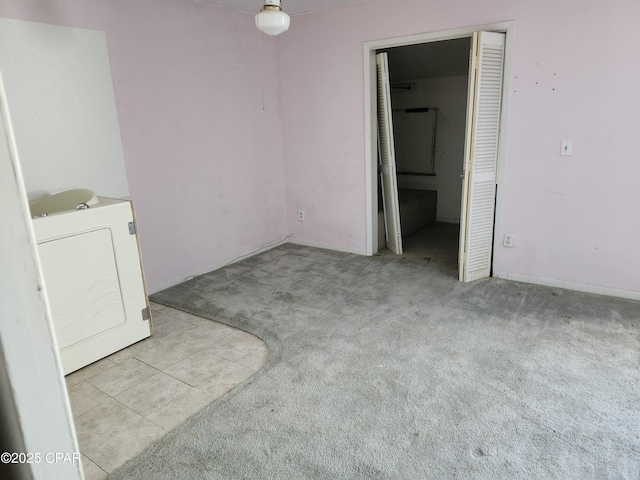 unfurnished bedroom featuring washer / dryer and light colored carpet