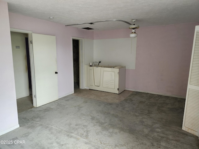 spare room featuring a textured ceiling, baseboards, and light colored carpet