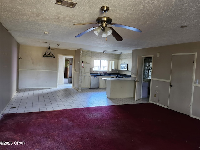 kitchen featuring dark countertops, visible vents, appliances with stainless steel finishes, light carpet, and white cabinetry